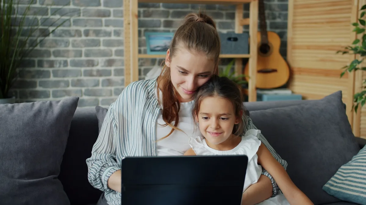 Mutter und Tochter besprechen gemeinsam am Laptop die passende Nachhilfe-Frequenz und den Preis